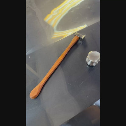 Ergonomic magnetic wooden handle of the PDR Uzbek blending hammer holding a metal knockdown pointer tool during professional auto body repair.
