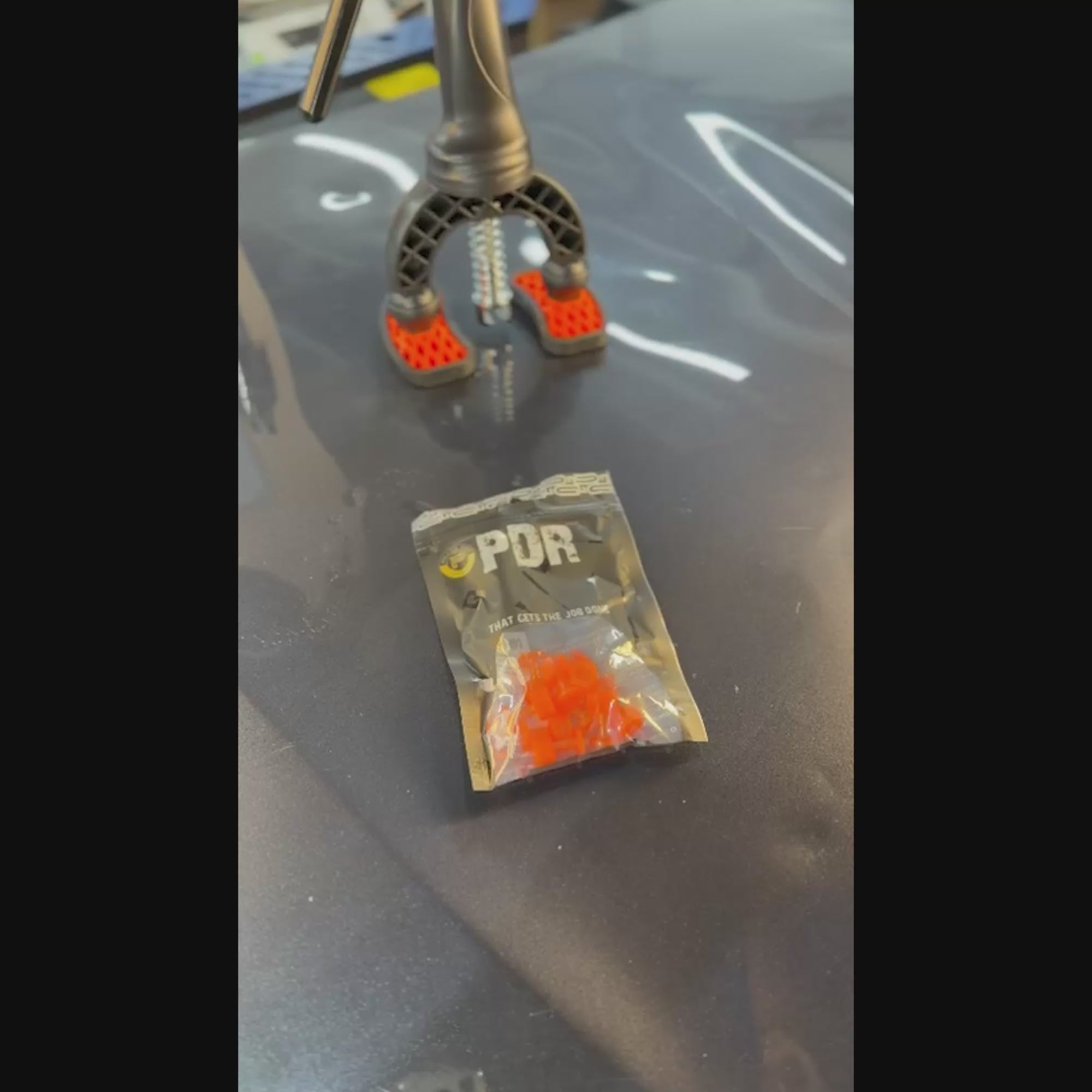 PDR INOX transparent round tab positioned on a small hail dent