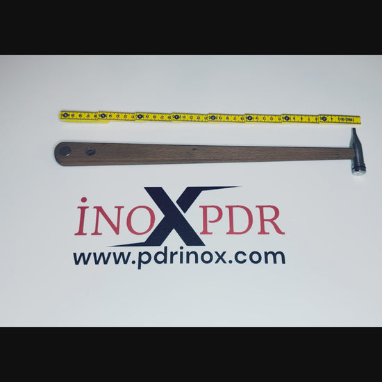 Professional stainless steel PDR hammer resting on a metal panel
